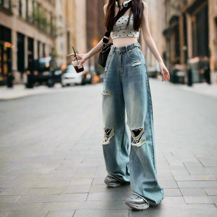 Person wearing ripped jeans and a crop top in an urban setting
