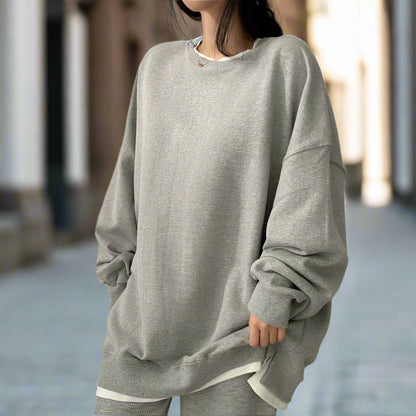 Person wearing a gray oversized sweatshirt
