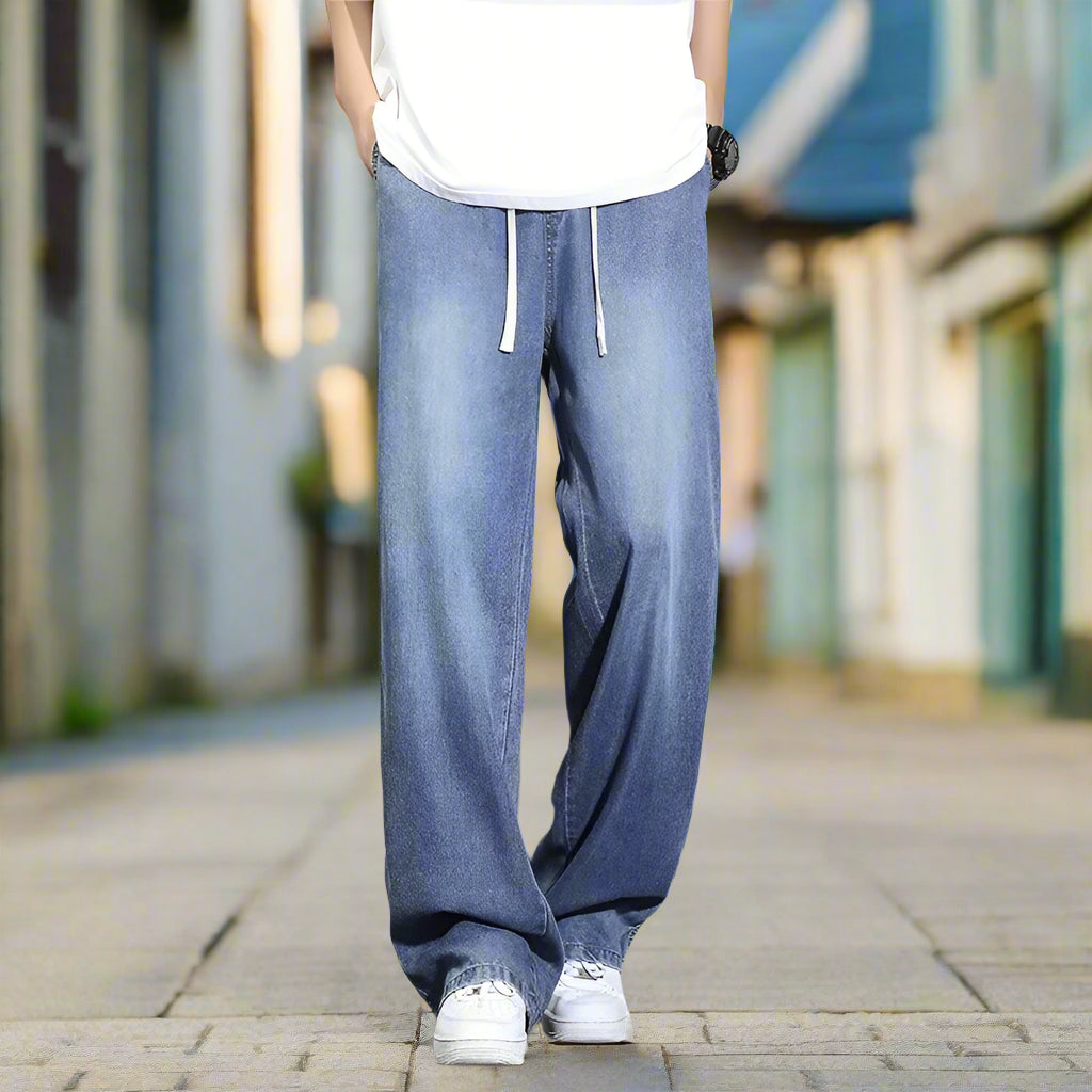 Person wearing light blue jeans and white sneakers on a old style street