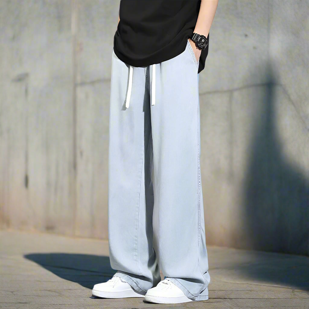 Light blue wide-leg pants worn with a black top against a gray background