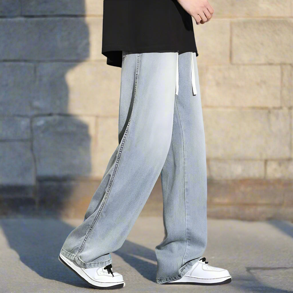 Light blue jeans worn by a person on a gray background